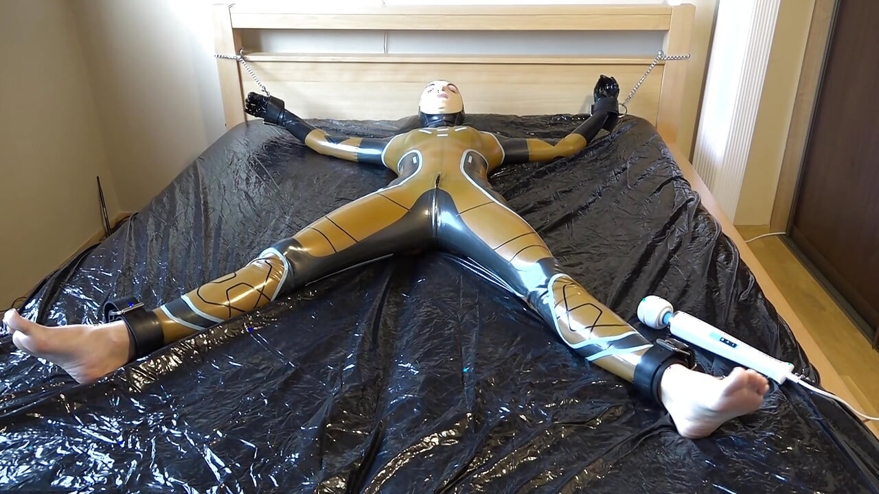 Latex Danielle is attached to the bed and masturbated with the massage vibrator