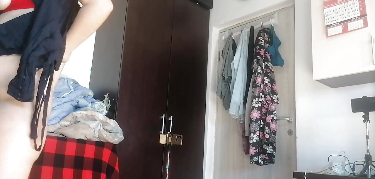 Amaterska žena pleše gola kod kuće. Amaterska žena se zabavlja isprobavajući odjeću i šišajući je.