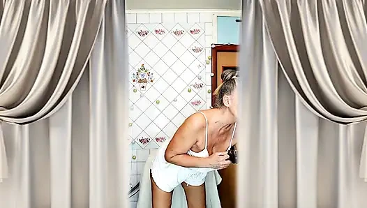 Real home solo of a mature woman in a small cozy kitchen.