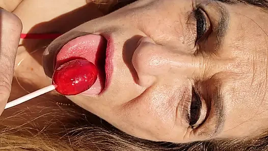 Melissa johnson lutscht und leckt einen kirschenlutscher am .beach