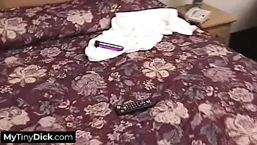 Eine schöne brünette, die hart bei der arbeit ihren kleinen schwanz lutscht
