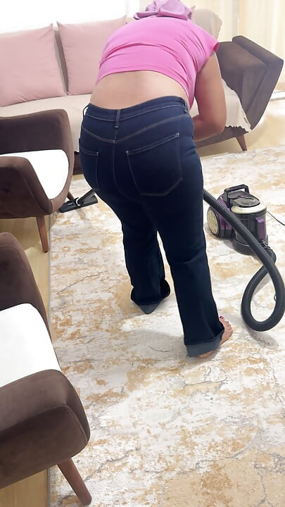 Curvy woman cleaning the house in trousers