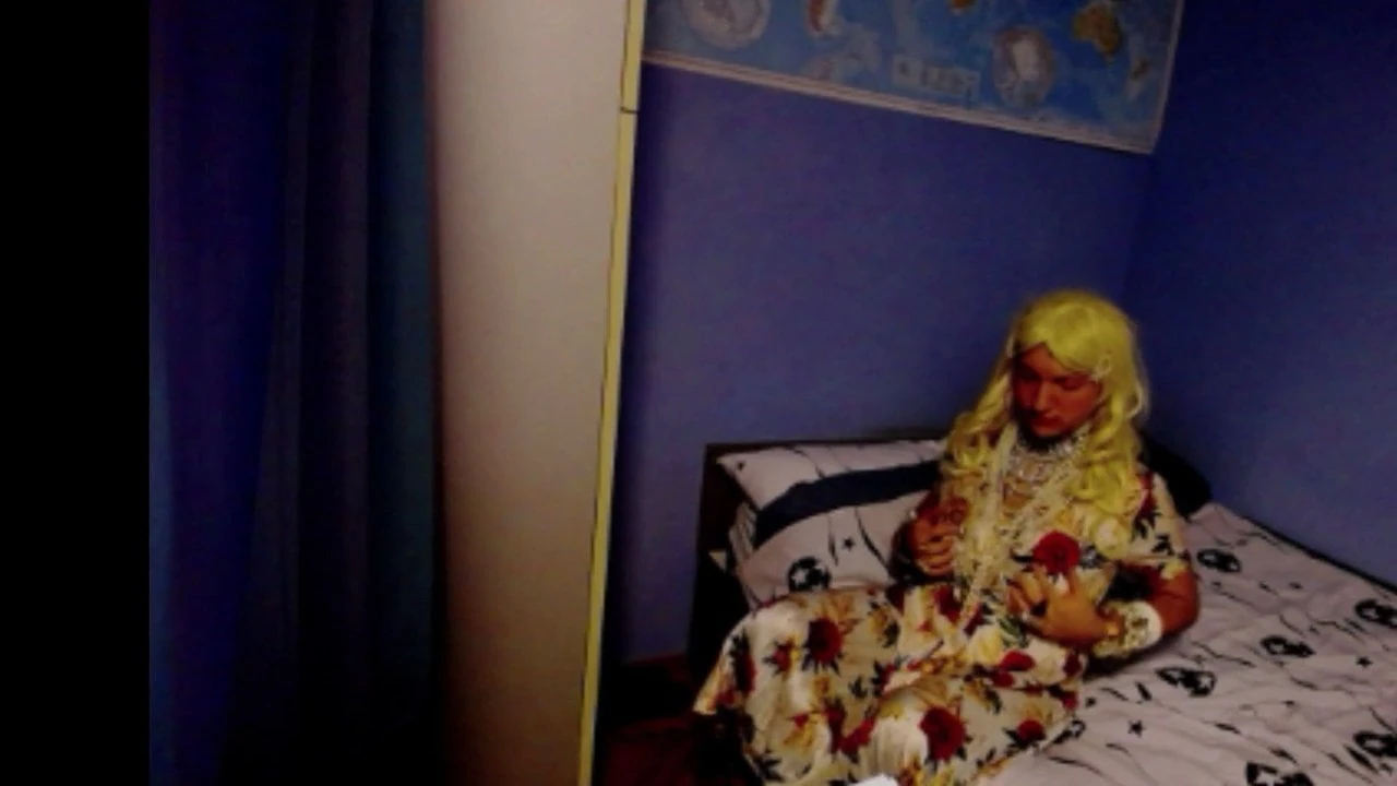 Travestiet in een jurk danst en komt klaar in bed