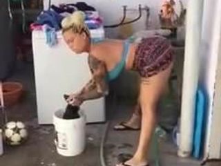 Señora sexy bailando mientras lava la ropa