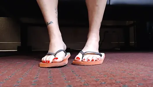 Игра с шлепантом обуви с красными ногтями крупным планом