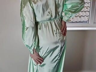 緑のサテンのドレスを着たテレビの女装者