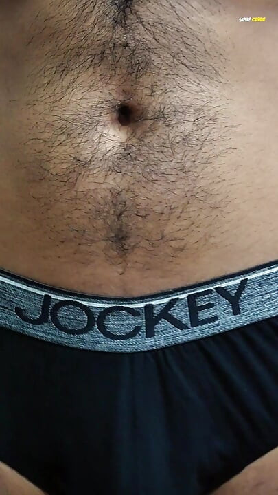 Young man wearing black underwear is dancing cock while holding his groin area.