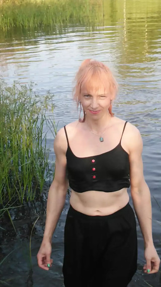 Transgirl swimming in clothes in lake wearing all black: pantyhose, skirt and top. Wetlook in lake.