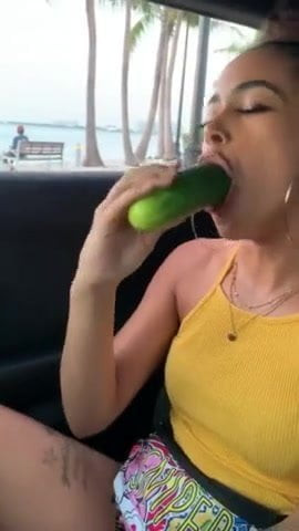 A women eating a cucumber