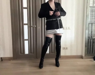 Sissy cuckold crossdresser in satin jacket, silk mini dress, high heels overknee boots dancing and playing with a cock