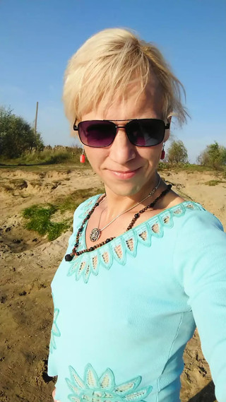 Trans girl swimming in the lake in clothes blue blouse and white-milk pants.