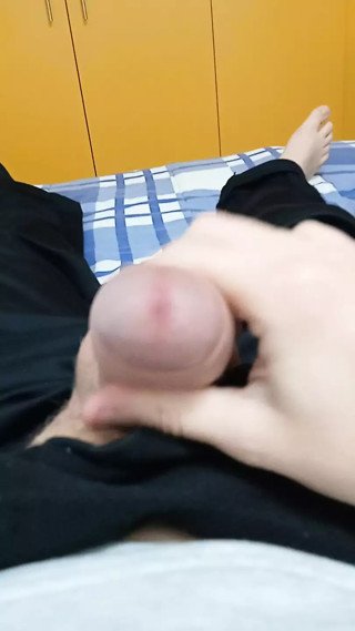 A young guy jerks off his big and fat dick with a sock