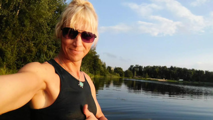 Swimming in the lake in sport wear at sunset.. Wet leggings and t-shirt... thumbnail