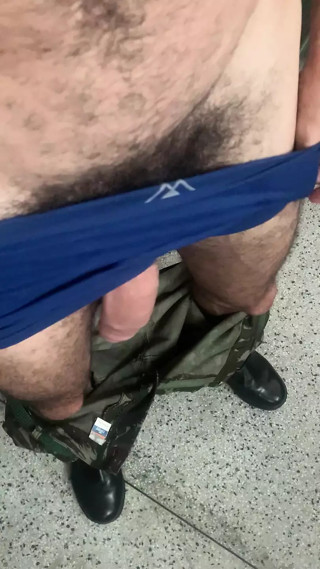 Military man in uniform in the barracks takes his huge soft hairy dick out of his pants waiting for a blowjob