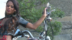 Outstanding brunette teasing outdoors by the chopper