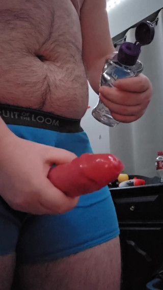 Chubby guy jerking off with condom through underwear hole