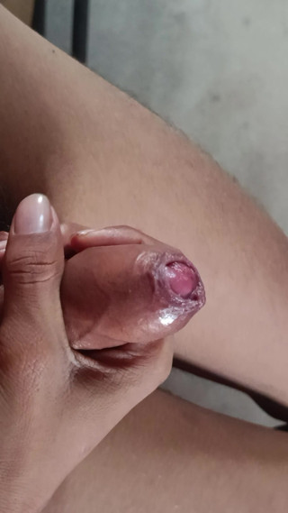 The boy is shaking his penis in his hand and ejaculating.