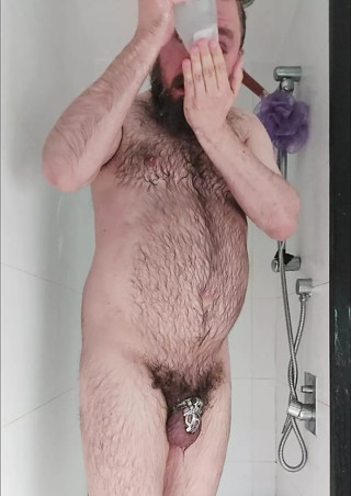 Hairy chastity bear showers and fingers his hole