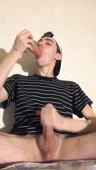 A young virgin sucks a dildo and jerks off his penis until he cums on his T-shirt