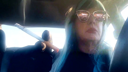 MATURE CD SMOKING &amp; DRIVING WITH A MB100 CIGARETTE IN HER GLOVED HAND