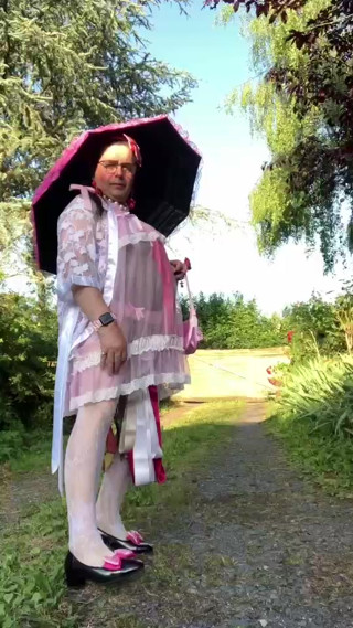 In an outfit with a pink nightgown and a sheer white dressing gown with a parasol thumbnail