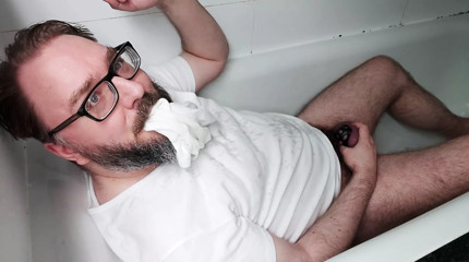 Chastity locked bear pisses his clothes and over himself