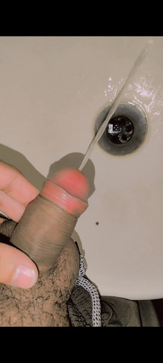 Young boy pissing in washroom