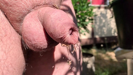 Uncut cock pissing through wet foreskin in the garden