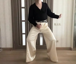 Sissy gay in satin silk palazzo wide leg trousers and black romantic women blouse on high heels overknee boots dancing thumbnail