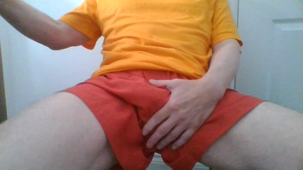 Wank in orange sports shorts