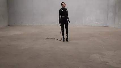 The Goddess Obsidian wields her bullwhips ominously in her latex catsuit.