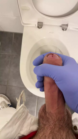 Jerking doctor at a toilet with latex gloves