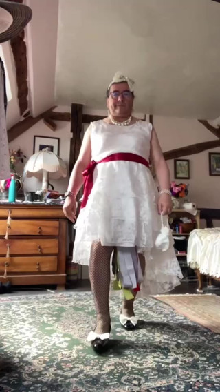 In an outfit with a long white lace dress styled like a wedding dress for an evening. thumbnail