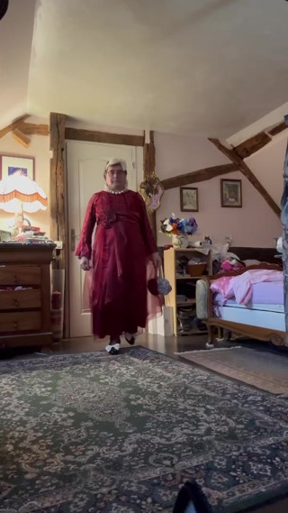 Dressed in a red evening gown for a party thumbnail