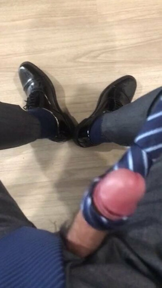 suited man plays with his tie