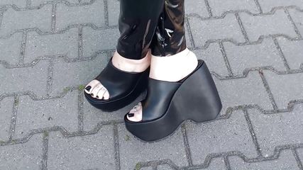 a walk in very high wedges and latex leggings