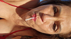 Melissa Johnson sucks and licks a cherry lollipop on the .beach