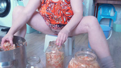 A milf in the kitchen does housework without panties