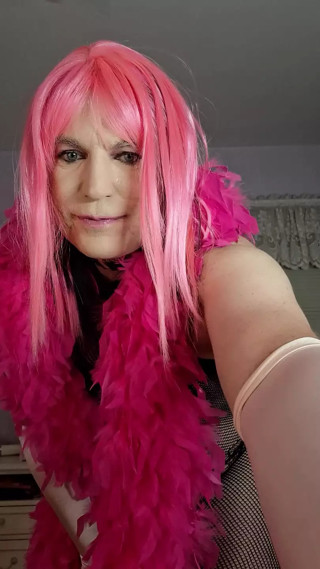 Black fishnet body stocking and pink feather boa, ass stuffed with pink vibrater