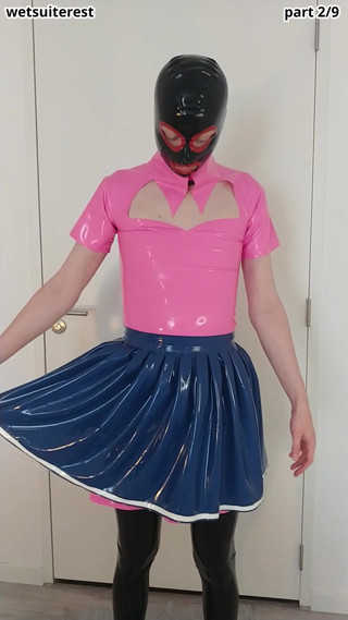 Putting on blue latex skirt over pink rubber maid dress and stockings, layers thumbnail